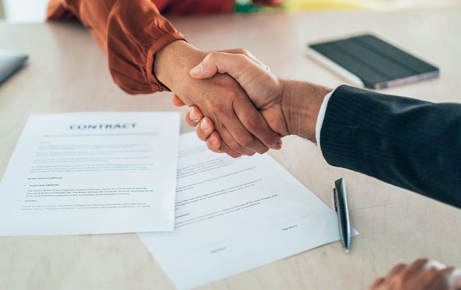 client and lawyer shaking hands after discussing a contract breach