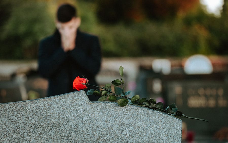 person at a grave in Houston, TX, for a loved one who had a wrongful death