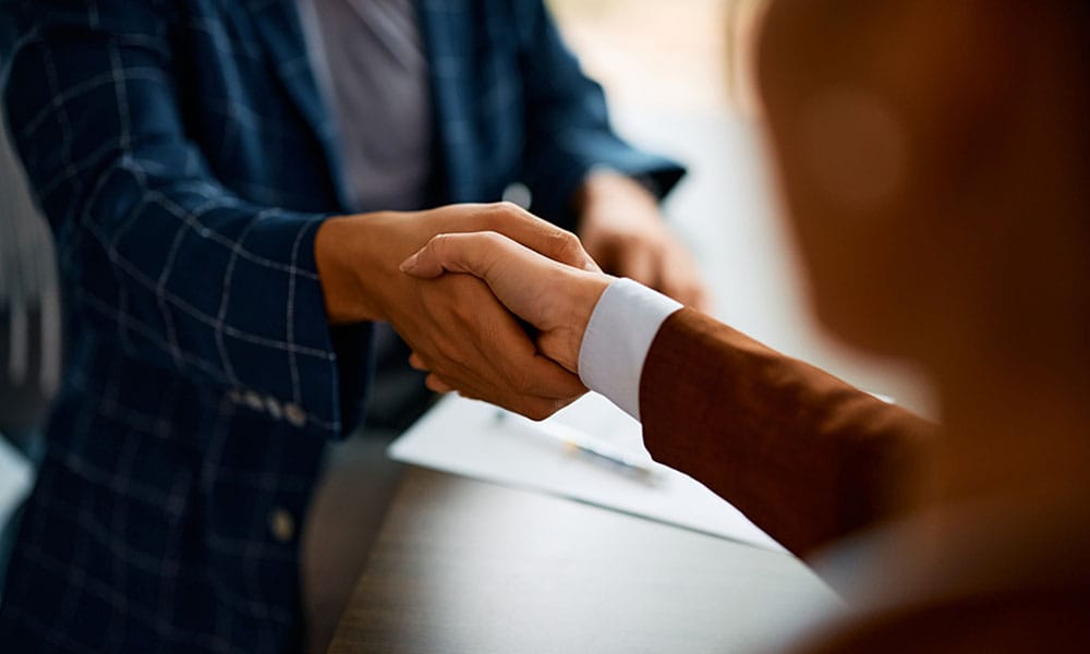 two people shaking hands over a contract in Houston, TX
